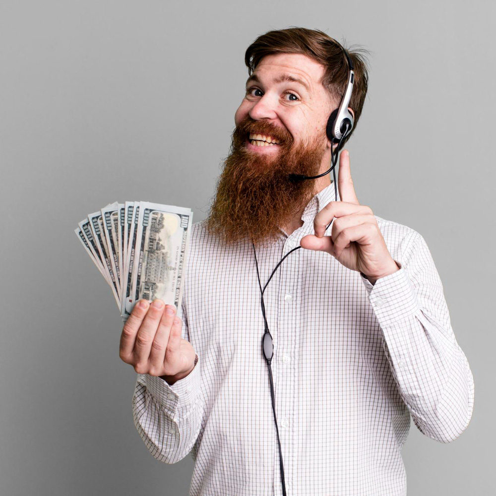 Man wearing a telephone headset, smiling and holding a fan of cash bills